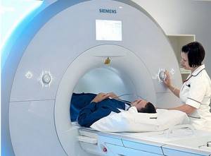 A man undergoes an MRI of the pelvis on a closed tomograph